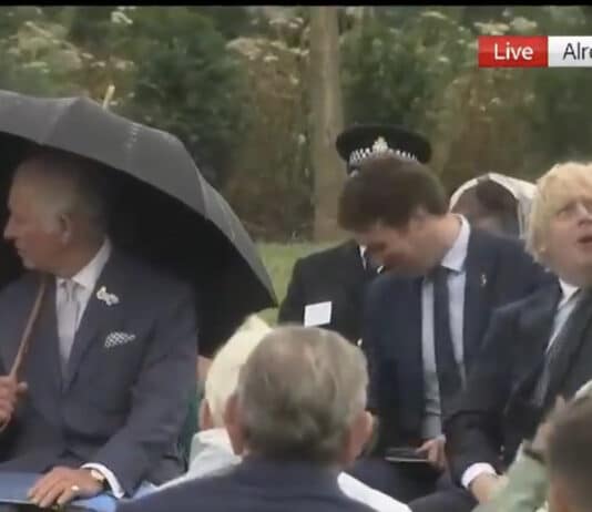 Boris Johnson gives a demonstration on how to put up an umbrella