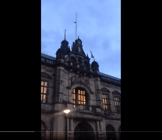 Man removes the flag of apartheid, terrorist state and replaces with a symbol of freedom